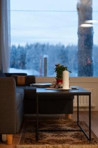 ein Wohnzimmer mit einem Tisch vor einem Fenster in der Unterkunft Saimaan Kodikas A3 in Savonlinna