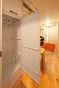 Biała lodówka z otwartymi drzwiami w pokoju w obiekcie Saimaan Kodikas A3 w mieście Savonlinna