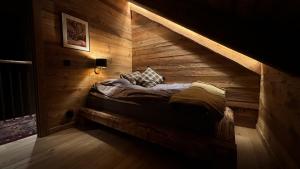 a bed in a room with a wooden wall at Chillouthouse Idre in Idre