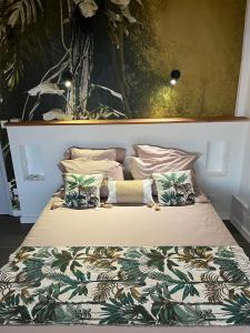 a bedroom with a large bed with a flowery blanket at Villa Cajou chambres d'hôtes chez l'habitant et Zanzibar cottage in Trois-Rivières