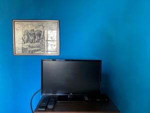 un computer portatile seduto su una scrivania accanto a una parete blu di Antica Dimora a Quartu SantʼElena
