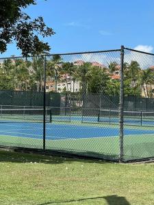 a tennis court with a fence in front of it at Carey Beach Villa in Humacao
