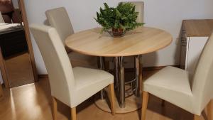 une table en bois avec des chaises et une plante en pot. dans l'établissement APP für alles & für jeden # 41199 in der City, mit Lift im HH, à Mönchengladbach
