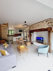 a living room with a couch and a table at Gîte Le Chambougeal in Lagraulière