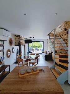 ein Wohnzimmer mit einem Tisch und einer Treppe in der Unterkunft Gîte Le Chambougeal in Lagraulière