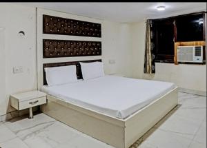 um quarto com uma grande cama branca num quarto em Mishra residency em Amritsar