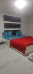 um quarto com uma cama com um cobertor vermelho em Mishra residency em Amritsar