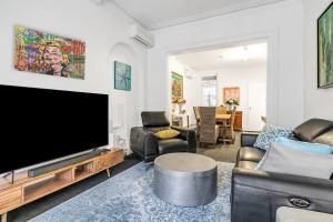 a living room with a large flat screen tv at 5 Bedroom Victorian Terrace in a Fab Location in Sydney