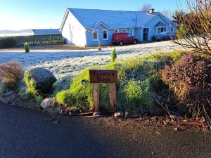 a sign in the grass in front of a house at Mountain Widok in Killorglin