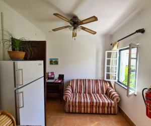 uma sala de estar com um sofá e uma ventoinha de tecto em Casa Vista da Serra - Covilhã em Covilhã