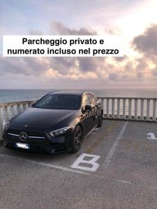 a black car parked on a road next to the ocean at T-Village502 in Anzio
