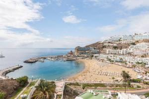 Una vista de una playa con edificios y el océano. en 1005 Ocean view house - Puerto Rico, en Puerto Rico de Gran Canaria