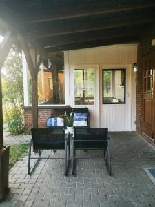 eine Terrasse mit 2 Stühlen und einem Tisch vor einem Haus in der Unterkunft Kleine Auszeit in Amelinghausen