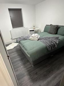 a bedroom with a green bed and wooden floors at 2Bed flat In Leicester ! in Leicester