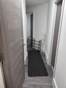 a hallway with a door and a black and white rug at 2Bed flat In Leicester ! in Leicester