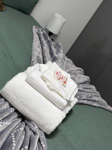 een stapel handdoeken bovenop een bed bij 2Bed flat In Leicester ! in Leicester