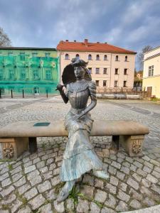 a statue of a woman sitting on a bench at Apartament exclusive Głuszyca in Głuszyca