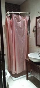 a bathroom with a pink shower curtain and a toilet at Résidence Le Moulin Ennasr 2 in Ariana