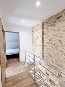 escalera en una habitación con pared de piedra en Gîte Le Chambougeal, en Lagraulière