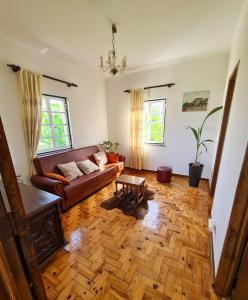 uma sala de estar com um sofá e um piso de madeira em Casa Vista da Serra - Covilhã em Covilhã