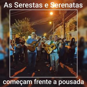 a group of people playing instruments on a street at Pousada no Centro de Conservatória Sandrinho ChicChic in Conservatória
