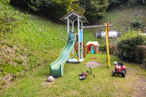 un parque infantil con un tobogán y un juego de juegos en Hotel Cima d'Oro, en Ledro