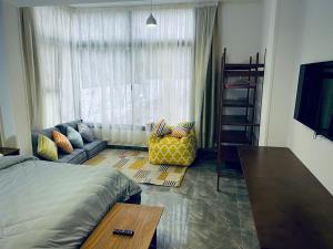 um quarto com uma cama, um sofá e uma janela em Rafiki - Guest House no Cairo