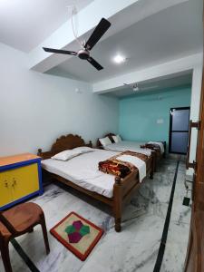 a bedroom with two beds and a ceiling fan at Bamni Tourist Lodge in Bāghmundi +16 photos