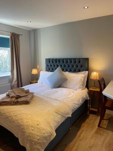 a bedroom with a large bed with white sheets and pillows at Stylish apartment, Taunton in Taunton