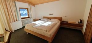 sypialnia z łóżkiem i oknem w obiekcie Pension Schlossberg w mieście Mittersill