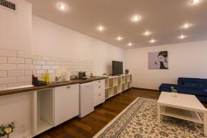 uma cozinha com armários brancos e um sofá azul em Terrace View Apartment em Timişoara