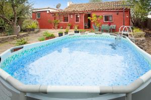 a large swimming pool with a house in the background at Casa Rural La Asomada in Vega de San Mateo