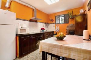 a kitchen with a table with a bowl of fruit on it at Casa Rural La Asomada in Vega de San Mateo