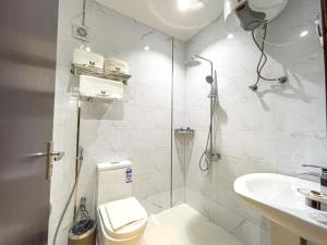 a bathroom with a shower and a toilet and a sink at Landmark Hotel Suites in Tabuk
