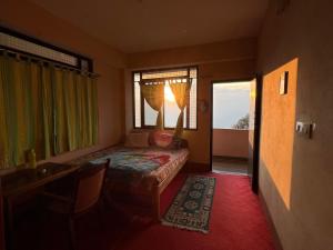 a bedroom with a bed and a window and a table at Hangkhim Homestay in Ravangla