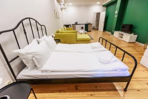un letto ospedaliero con lenzuola e cuscini bianchi in una stanza di A3 Delux Studio Saffron a Plovdiv