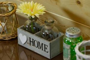 a vase with a flower in a box with a home sign at Camping pod Lyts Dekema 1 in Baard