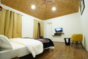 um quarto com uma cama e uma televisão na parede em Nature's Edge Nishat Srinagar em Srinagar