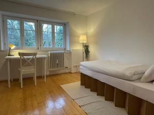 1 dormitorio con cama, escritorio y ventana en Wohnung mit 3 Schlafzimmern, Dachterrasse und Flussblick, en Ühlingen-Birkendorf