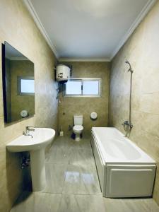 uma casa de banho com um lavatório, uma banheira e um WC. em Rafiki - Guest House no Cairo