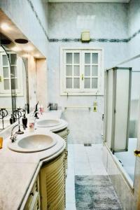 a bathroom with two sinks and a shower at Luxury Vacation Villa in Cairo