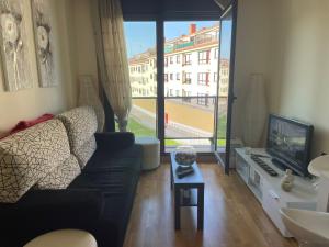 a living room with a couch and a tv at Recuncho Costeiro in Baiona