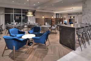 un restaurante con mesas y sillas azules y un bar en Courtyard by Marriott Burlington-Oakville en Burlington