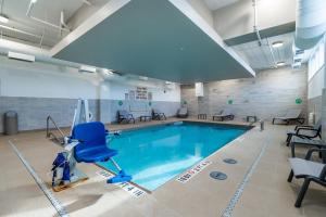 - une piscine avec une chaise bleue dans un bâtiment dans l'établissement Courtyard by Marriott Burlington-Oakville, à Burlington