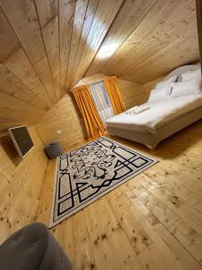 a bedroom with a bed and a rug on the floor at Cabana EviMat Azuga in Azuga