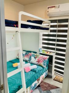 a bedroom with two bunk beds and a desk at JNL Victoria Sports Towers condo - GMA, Quezon city in Manila