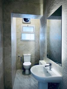 a bathroom with a white toilet and a sink at Rafiki - Guest House in Cairo