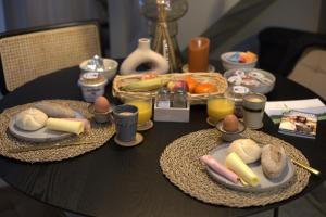 une table noire contenant des assiettes de nourriture et des œufs dans l'établissement B&B De Groene Driehoek 'A', à Sint Agatha