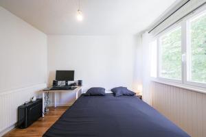 - une chambre avec un lit et un bureau avec un ordinateur dans l'établissement T4 spacieux tout confort / parking gratuit, à Grenoble