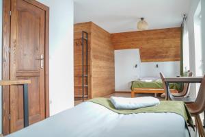 1 dormitorio con 1 cama y puerta de madera en Goralsko Manufaktura, en Bukowina Tatrzańska